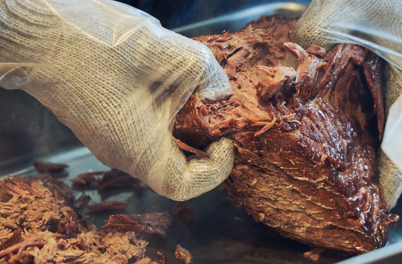 オーストラリア産グラスフェッド・ビーフのモモ肉を180℃のオーブンで2時間以上加熱すると、肉が繊維にそってホロホロと崩れやすくなっている。プルド(引っ張った)という意味通り、焼きあがった肉を手で崩していく、アメリカのBBQの定番調理法だ。