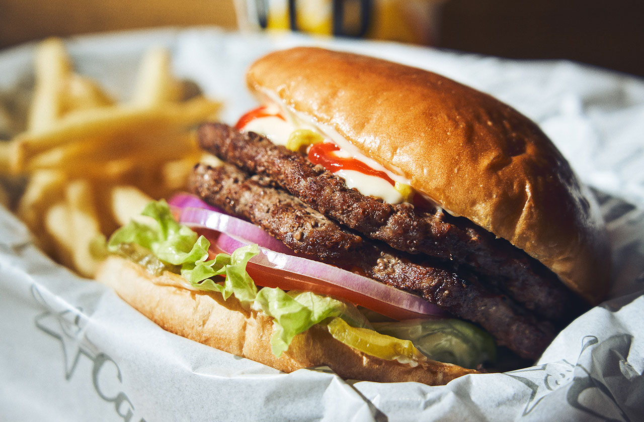 カールスジュニアのベストメニュー「ORIGINAL ANGUS BURGER（オリジナル アンガスバーガー）」（1150円、ポテトは別売り）にアンガスバーガーパティ1枚（430円）を追加した。直火焼きのオーストラリア産アンガスビーフのパティ、レッドチェダーチーズ、ピクルス、マヨネーズタイプソース、マスタード、ケチャップをバンズでサンドしている。