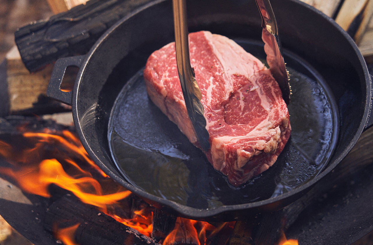 焼く面だけに塩とコショウを振って焼きはじめる。「反対側の面は、フライパンの上で塩とコショウを振ればいいんです。その方が周りが汚れないでしょ」と田中さん。