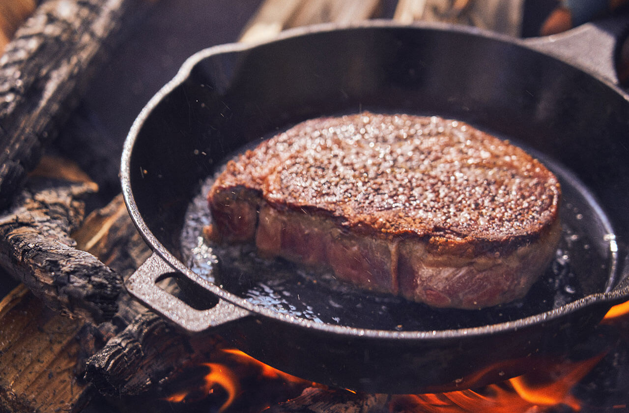 焼き色がしっかりついたら肉を裏返す。「断面を押しながら焼き加減をみていきます。親指と人差し指でリングを作った時の親指の付け根の弾力が、レアといわれていますので試してみてください」。