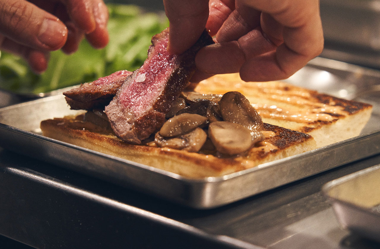 鉄板で焼いたオーストラリア産グレインフェッド(穀物肥育)ビーフにモッツァレラチーズ、ルッコラ、アップルチャツネ、マッシュルームがサンドされた贅沢なひと品。
