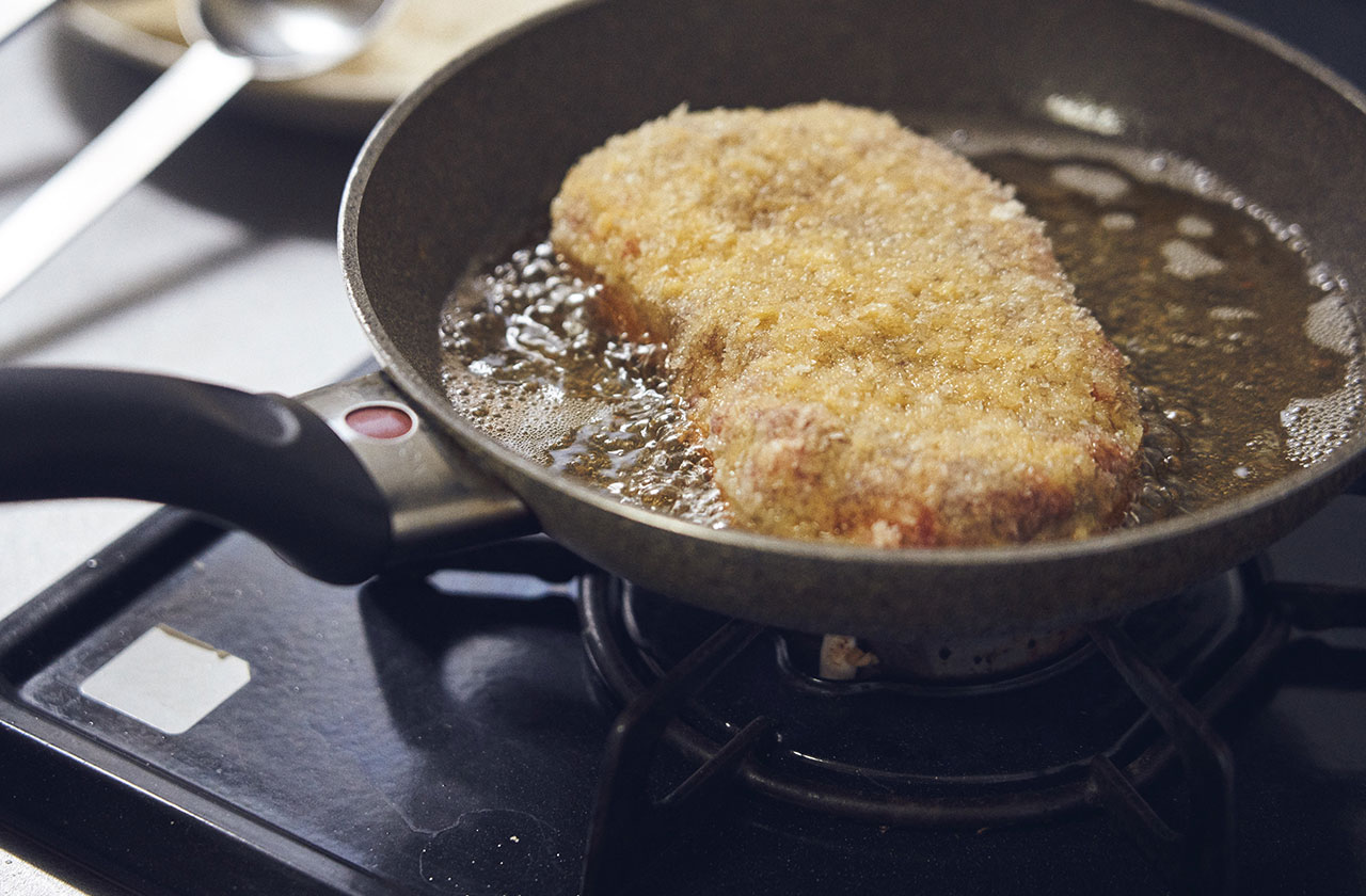 揚げ油も肉が半分浸かる程度で揚げ焼きに。厚さや大きさにもよるが、この日の肉の大きさなら片面1分ずつ、合計2分ほど揚げる。油を切り、3分ほど休ませてからカットする。