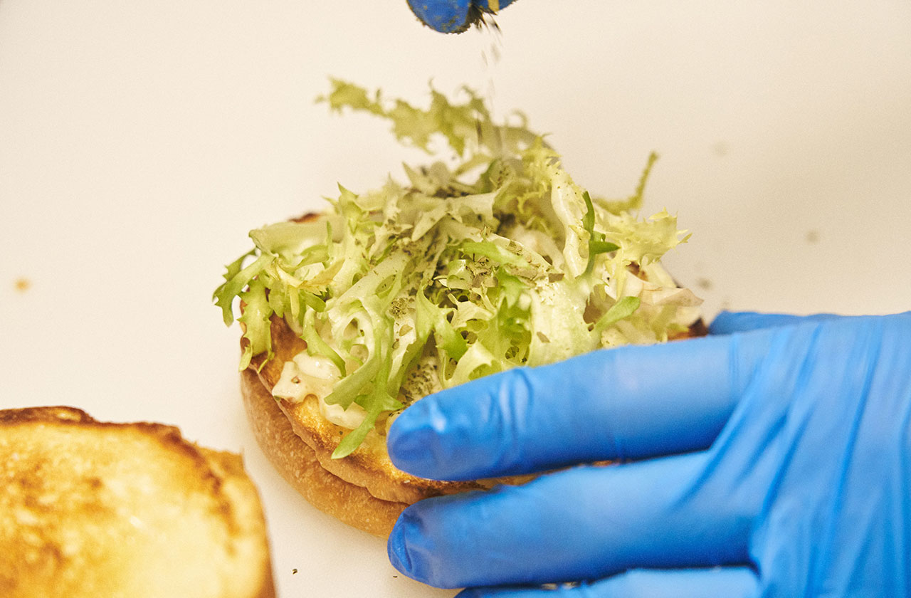 ハンバーガーに挟む葉物野菜は、レタスが多いがオセマニアでは、独特の苦みがある西洋野菜のエンダイブを使っている。水分が少なく味をぼやけさせない。さらにここにオーストラリア産のハーブ「レモンマートル」とタスマニア産ペッパーをふりかける。このハーブとスパイスが、オセマニアのハンバーガーを特徴的にしているポイントで、肉の風味をギュっと凝縮させ、さらには苦味のあるエンダイブとの間を取りもつような役割も果たし、ハンバーガーに一体感を与えている。